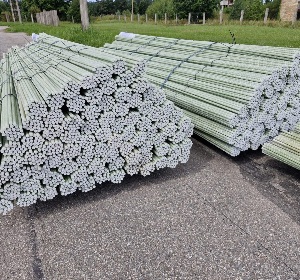 Bundles of GFRP composite rebars stacked and secured outdoors, ready for shipment. Fiberglass reinforcement bars tied in uniform lengths demonstrate organized storage and construction-ready composite reinforcement materials.